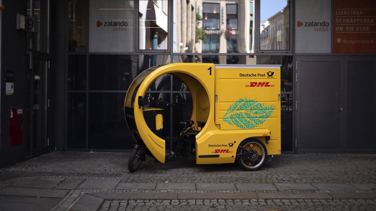 Ein DHL-Wagen steht vor einem Zalando-Geschäft in Leipzig.