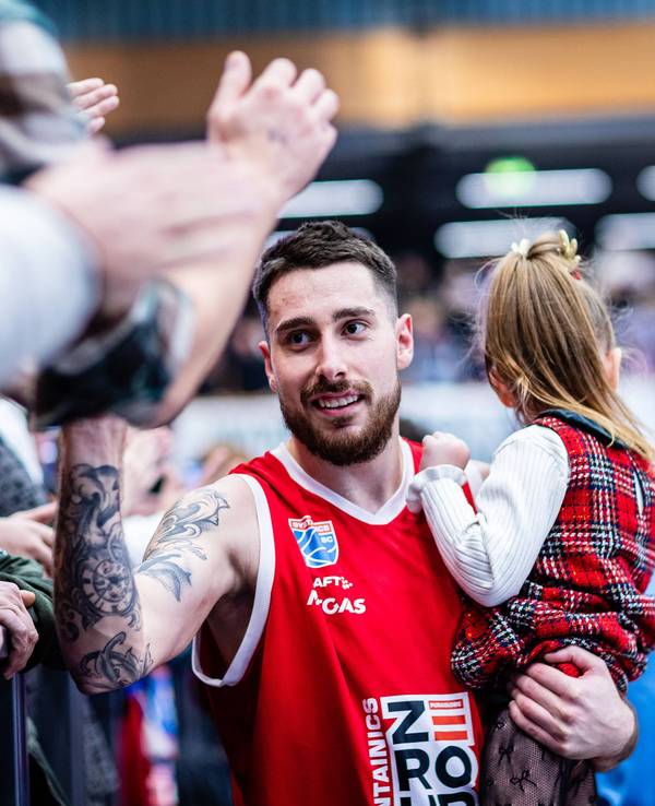 Ivan Tkachenko schlägt mit seiner Tochter im Arm mit einigen Fans ein.