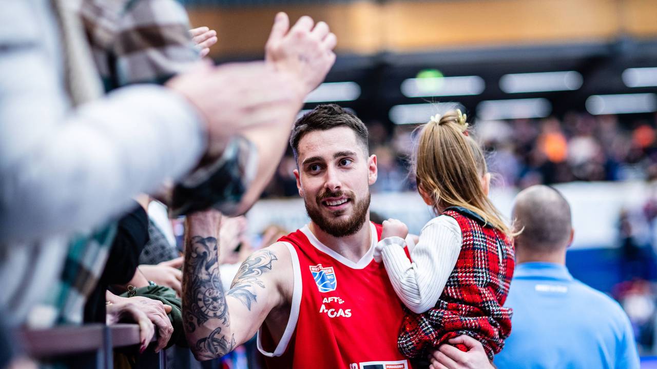 Ivan Tkachenko schlägt mit seiner Tochter im Arm mit einigen Fans ein.