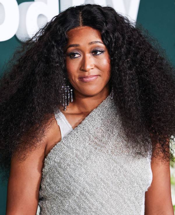 Naomi Osaka posiert in einem silbergrauen Kleid auf dem roten Teppich.