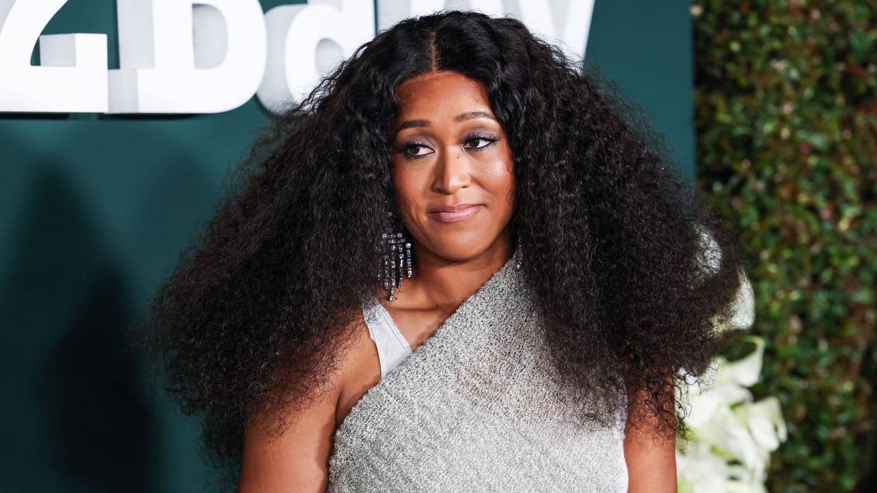 Naomi Osaka posiert in einem silbergrauen Kleid auf dem roten Teppich.