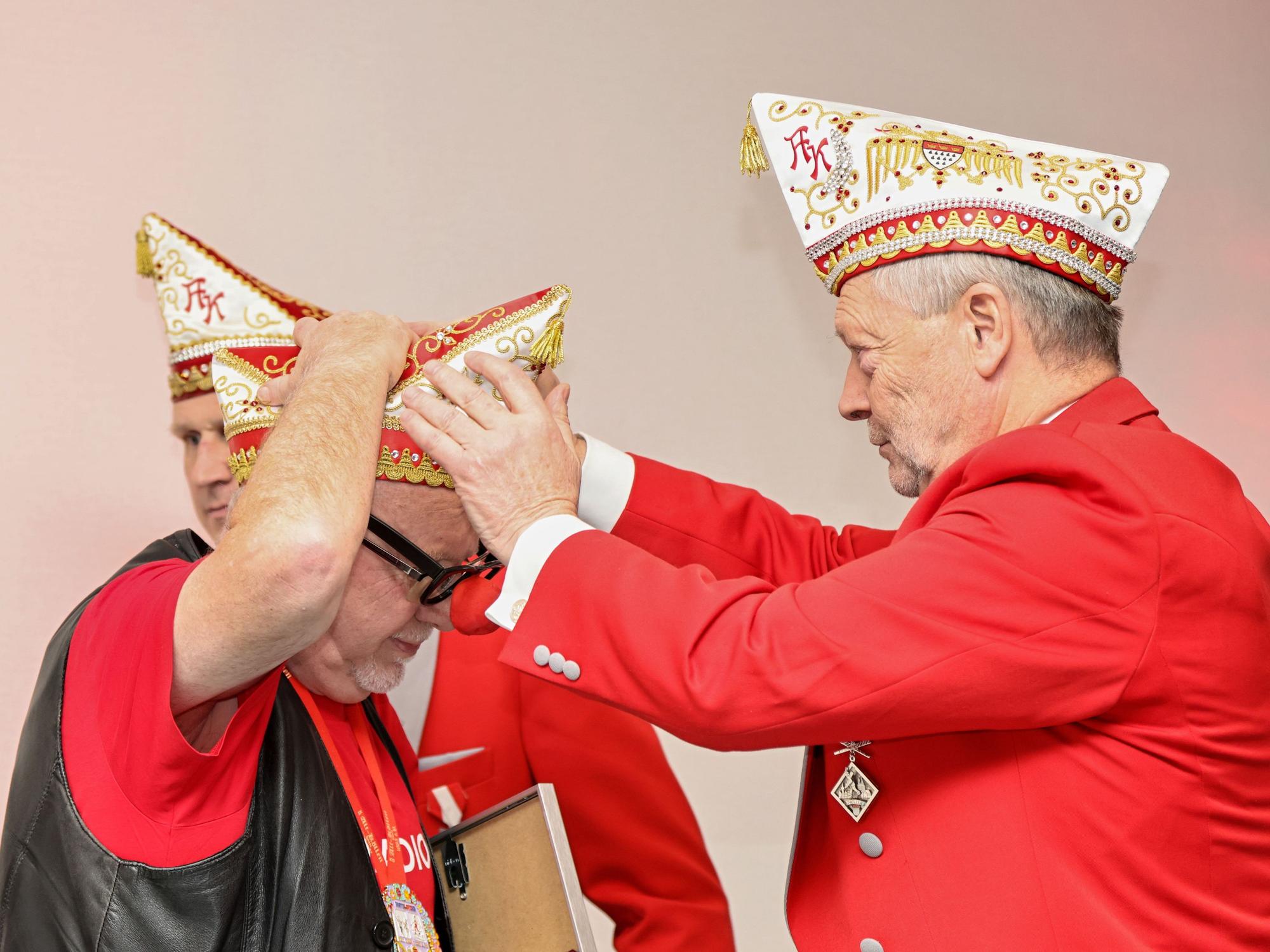 Gregor Berthold setzt Willibert Pauels die Mütze auf.