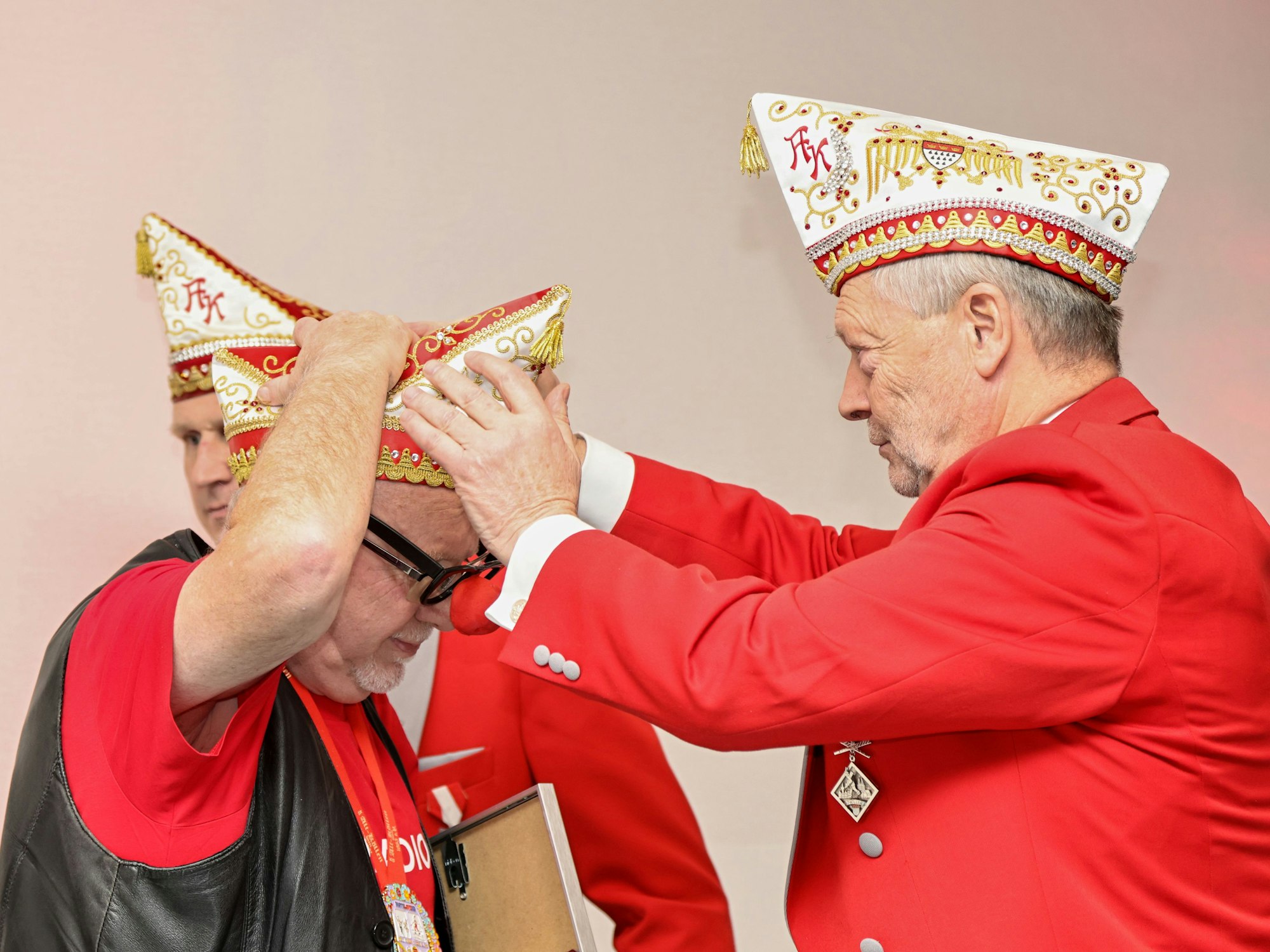 Gregor Berthold setzt Willibert Pauels die Mütze auf.