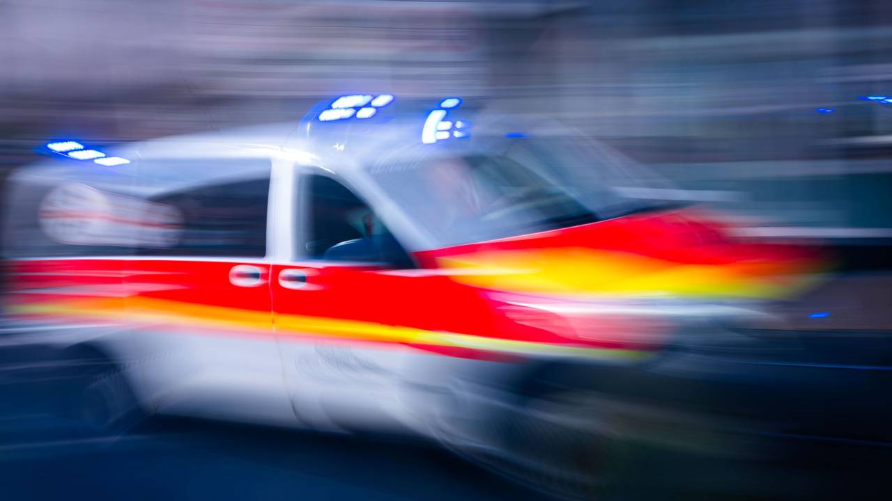 Ein Rettungsfahrzeug ist mit Blaulicht auf einer Straße unterwegs.