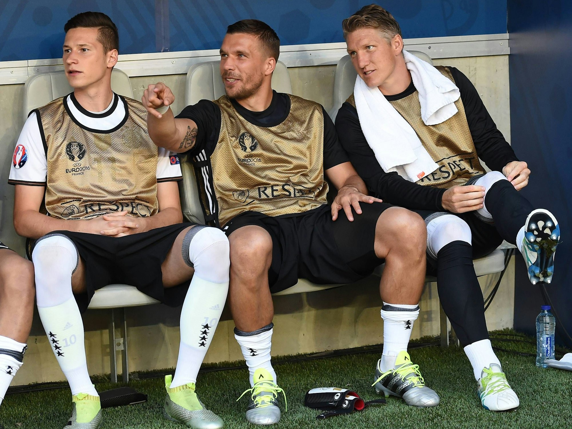 Julian Draxler (l.), Lukas Podolski (M.) und Bastian Schweinsteiger sitzen auf der Ersatzbank.