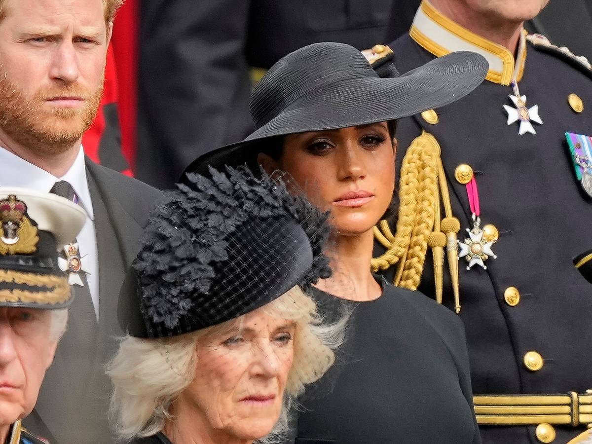 König Charles III. (vorn), Königsgemahlin Camilla, Prinz Harry (dahinter), Herzog von Sussex, und seine Frau Meghan, Herzogin von Sussex, schauen auf den Trauerzug mit dem Sarg der gestorbenen britischen Königin.