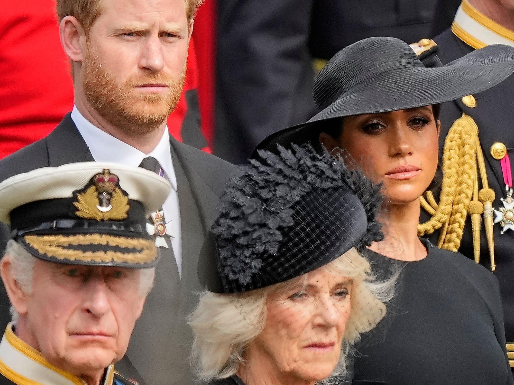 König Charles III. (vorn), Königsgemahlin Camilla, Prinz Harry (dahinter), Herzog von Sussex, und seine Frau Meghan, Herzogin von Sussex, schauen auf den Trauerzug mit dem Sarg der gestorbenen britischen Königin.