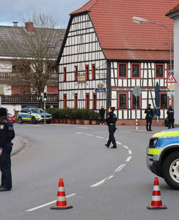 Einsatzkräfte der Polizei stehen in Rimbach vor der Bankfiliale, in der es zu einer Geiselnahme kam.