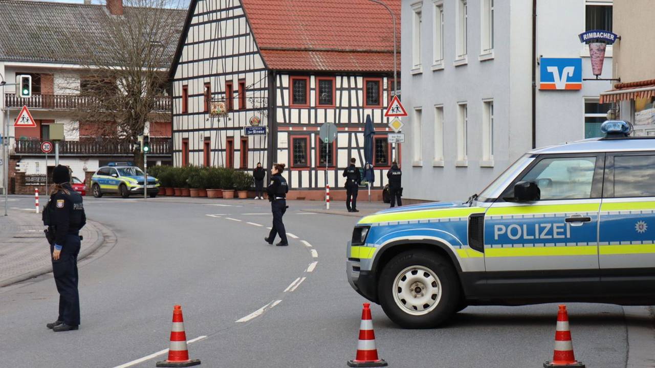 Einsatzkräfte der Polizei stehen in Rimbach vor der Bankfiliale, in der es zu einer Geiselnahme kam.