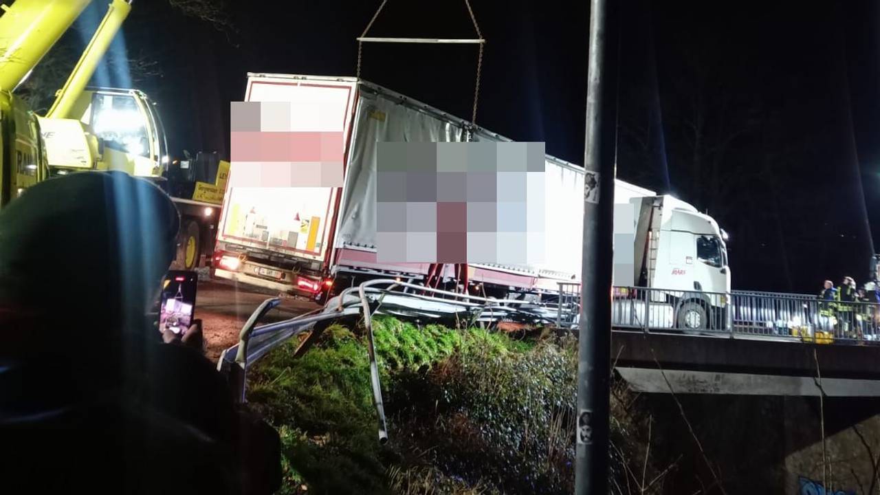 Ein Kran sichert einen auf einer Brücke bei Gummersbach festgefahrenen Lastwagen. Der Lkw droht auf die Bahngleise zu stürzen.