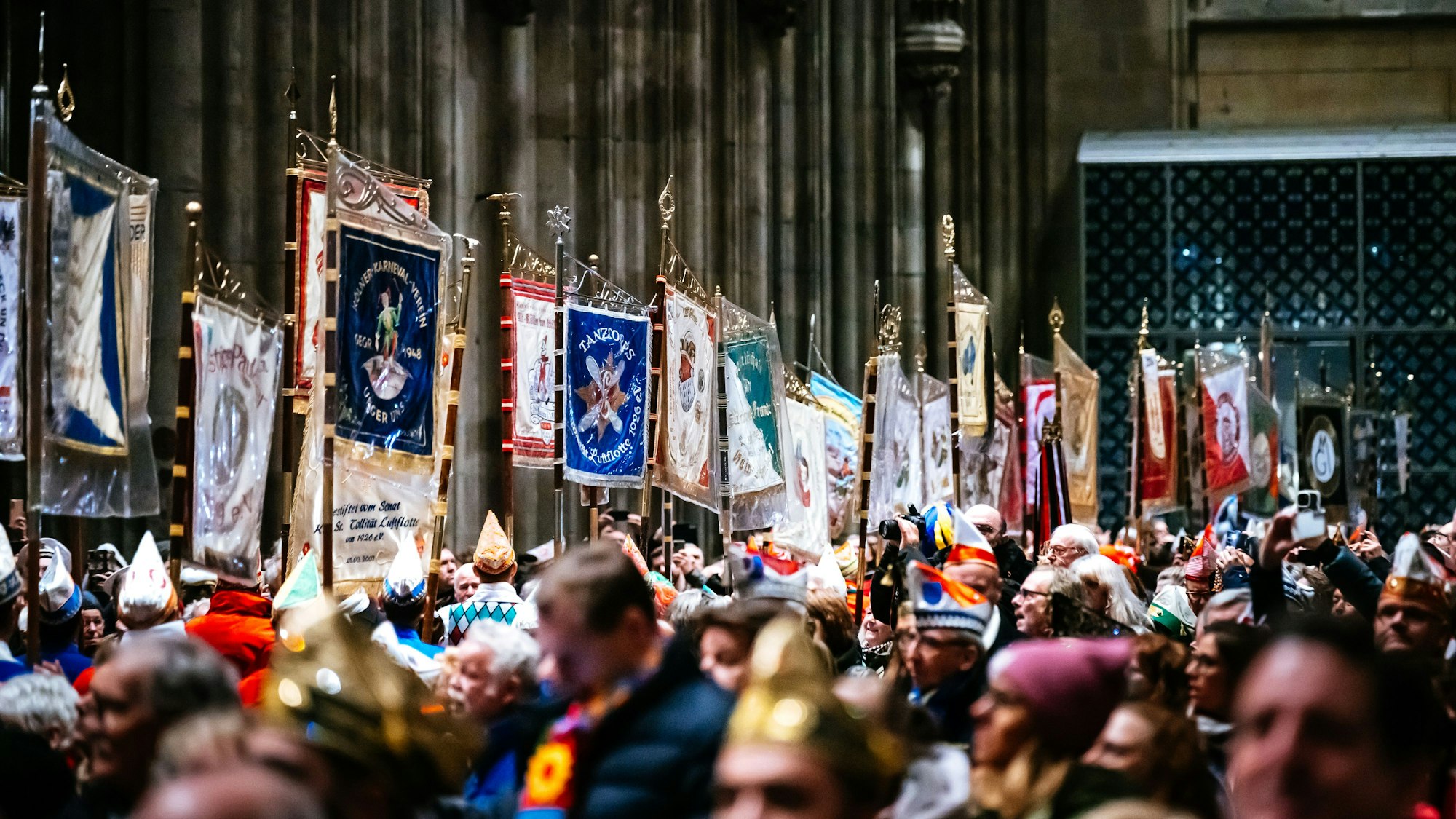 Gottesdienstes für die Kölner Karnevalisten im Kölner Dom, Plaggen und Fahnen ziehen auf.
