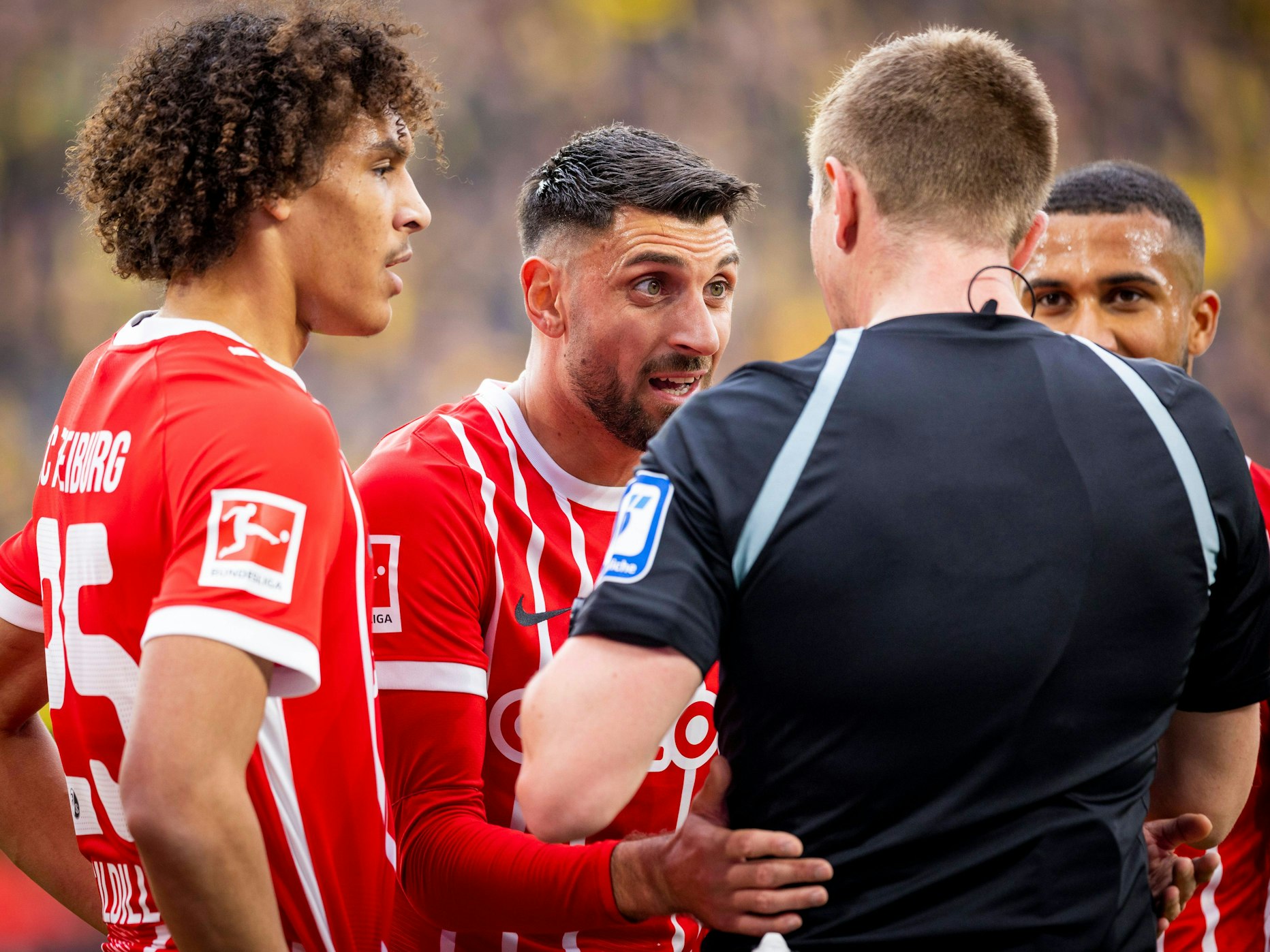 Kiliann Sildillia, Vincenzo Grifo und Daniel-Kofi Kyereh beschweren sich beim Schiedsrichter.