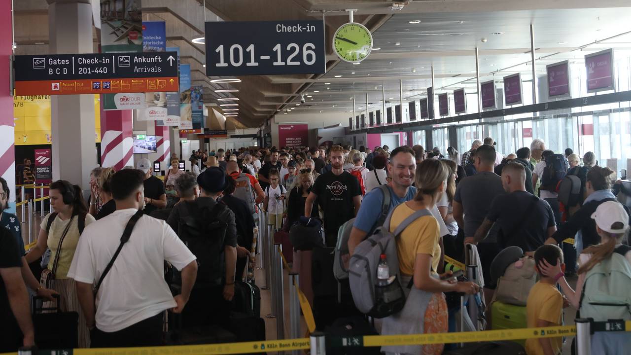 Menschen stehen am Flughafen Köln/Bonn in der Schlange vor dem Check-in.