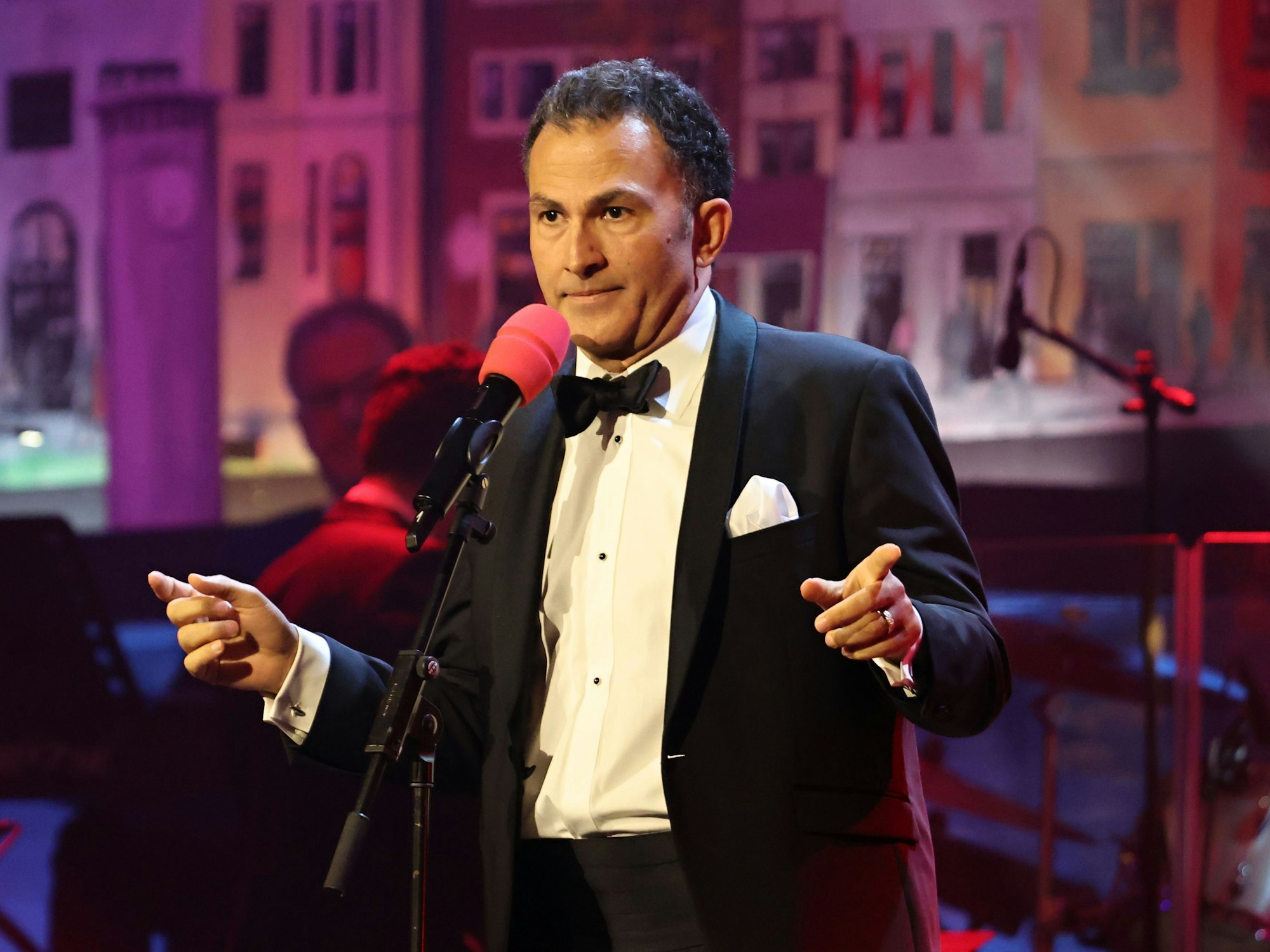 Der Comedian Fatih Cevikkollu steht auf der Bühne.