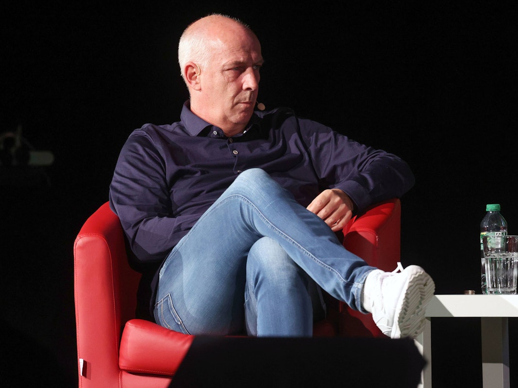 Mario Basler sitzt in einem roten Sessel.