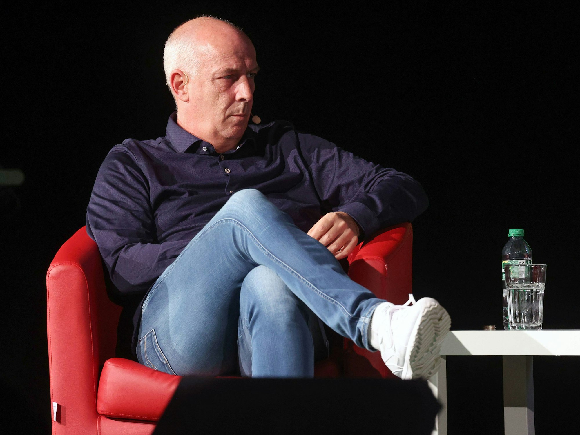 Mario Basler sitzt in einem roten Sessel.