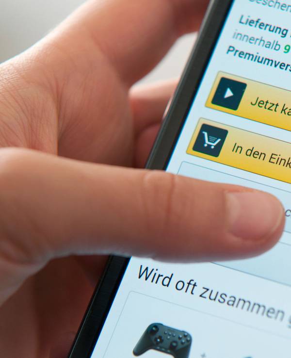 Amazon ersetzt „Prime Wardrobe“ künftig durch KI. Das Symbolfoto aus dem Jahr 2015 zeigt eine Person beim Bestellen auf dem Smartphone.
