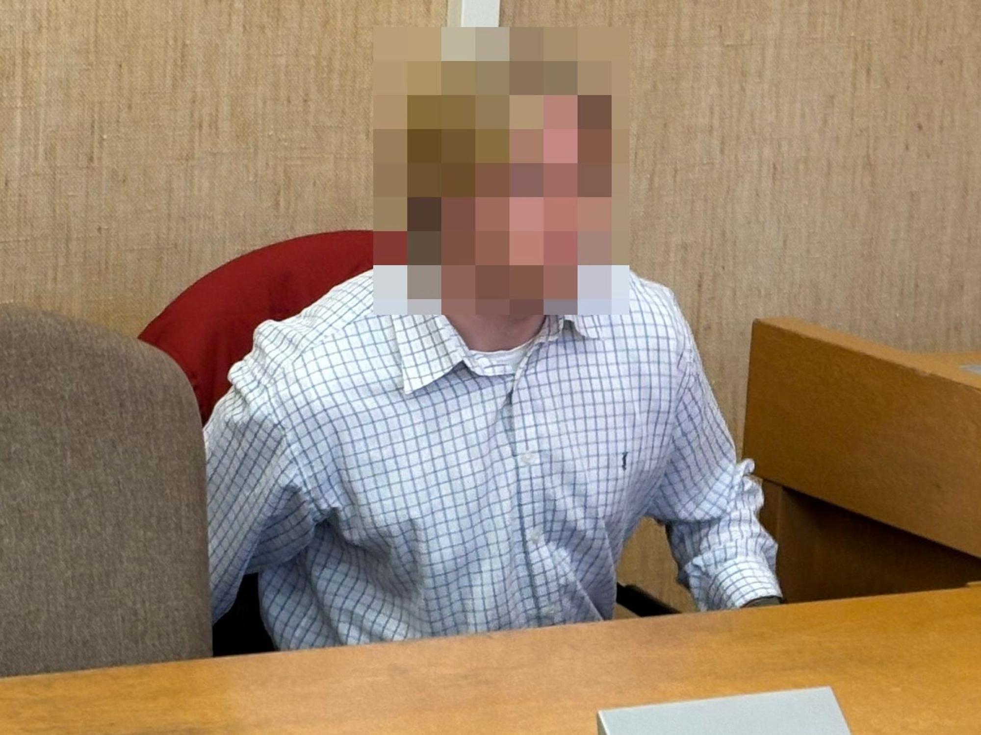 Ein junger Mann sitzt im Gericht.