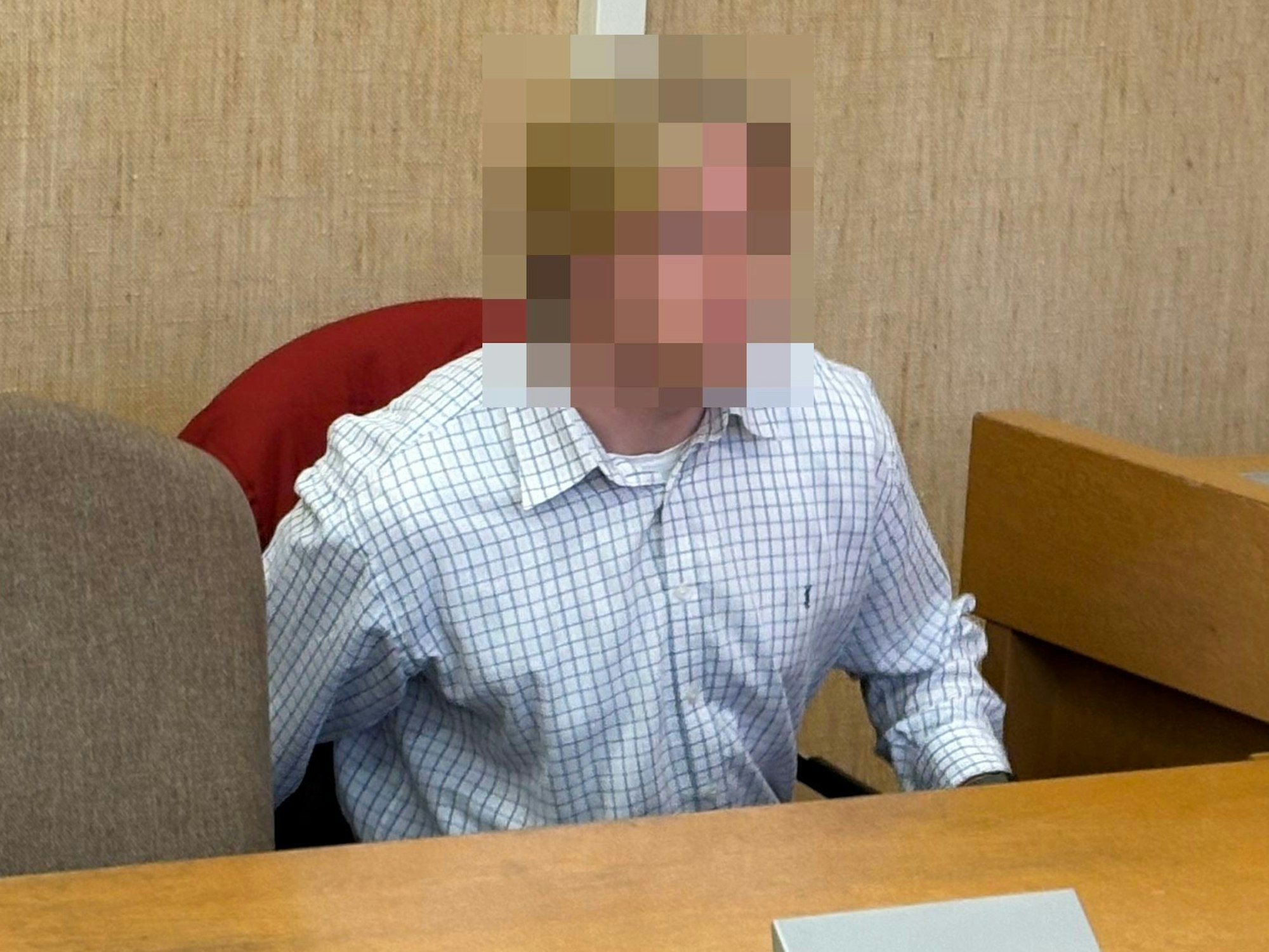 Ein junger Mann sitzt im Gericht.