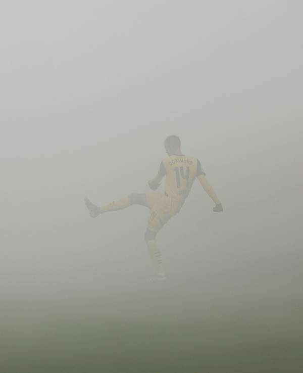 Dortmund-Profi Maximilian Beier passt den Ball im Auswärtsspiel bei Holstein Kiel. Der Platz ist in dicken Nebel gehüllt.