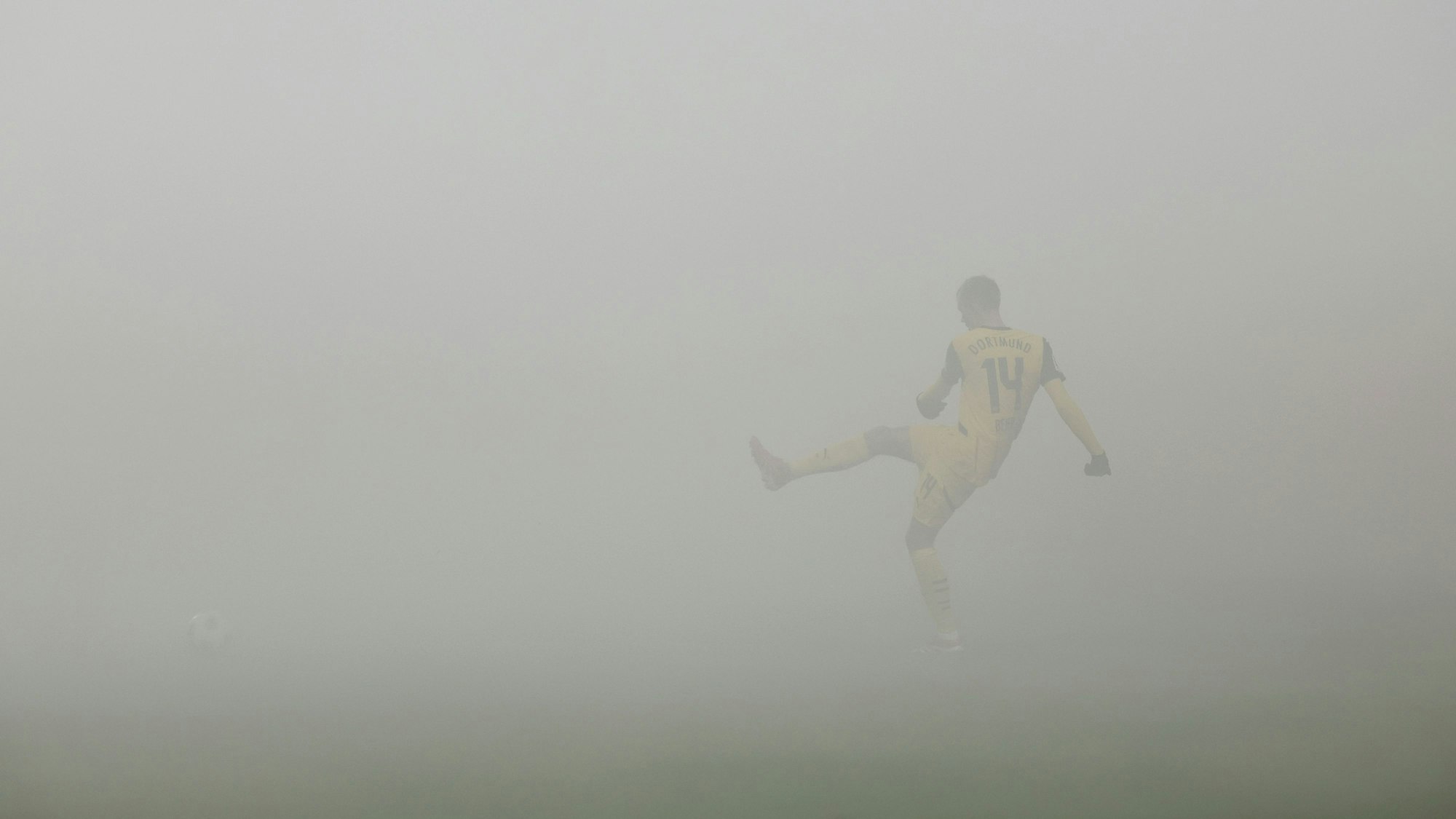 Dortmund-Profi Maximilian Beier passt den Ball im Auswärtsspiel bei Holstein Kiel. Der Platz ist in dicken Nebel gehüllt.