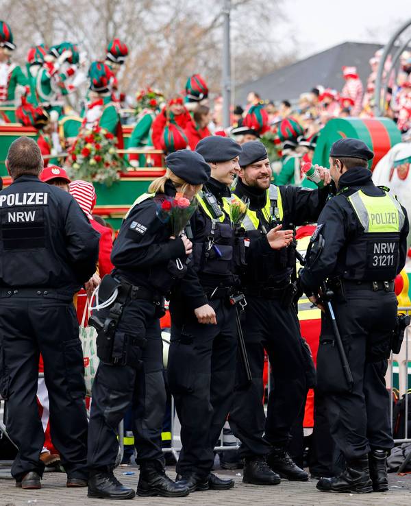 Einsatzkräfte der Polizei stehen am Rande des Kölner Karnevalszugs.