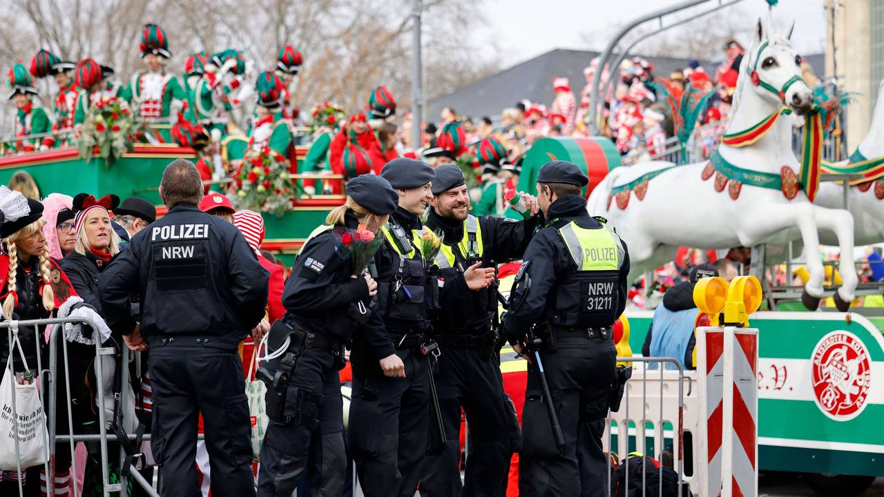 Einsatzkräfte der Polizei stehen am Rande des Kölner Karnevalszugs.