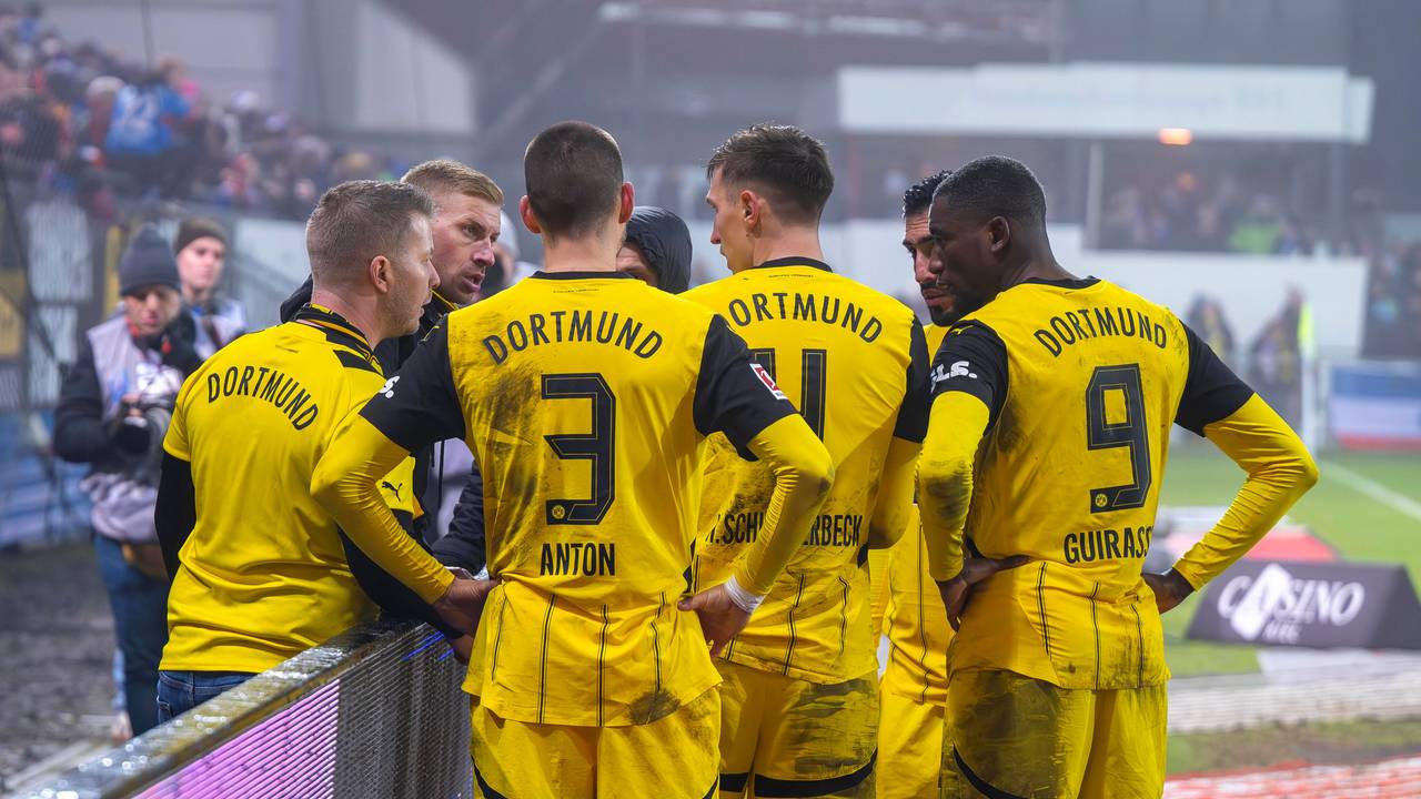 Vier BVB-Profis sprechen an der Werbebande mit Ultras.