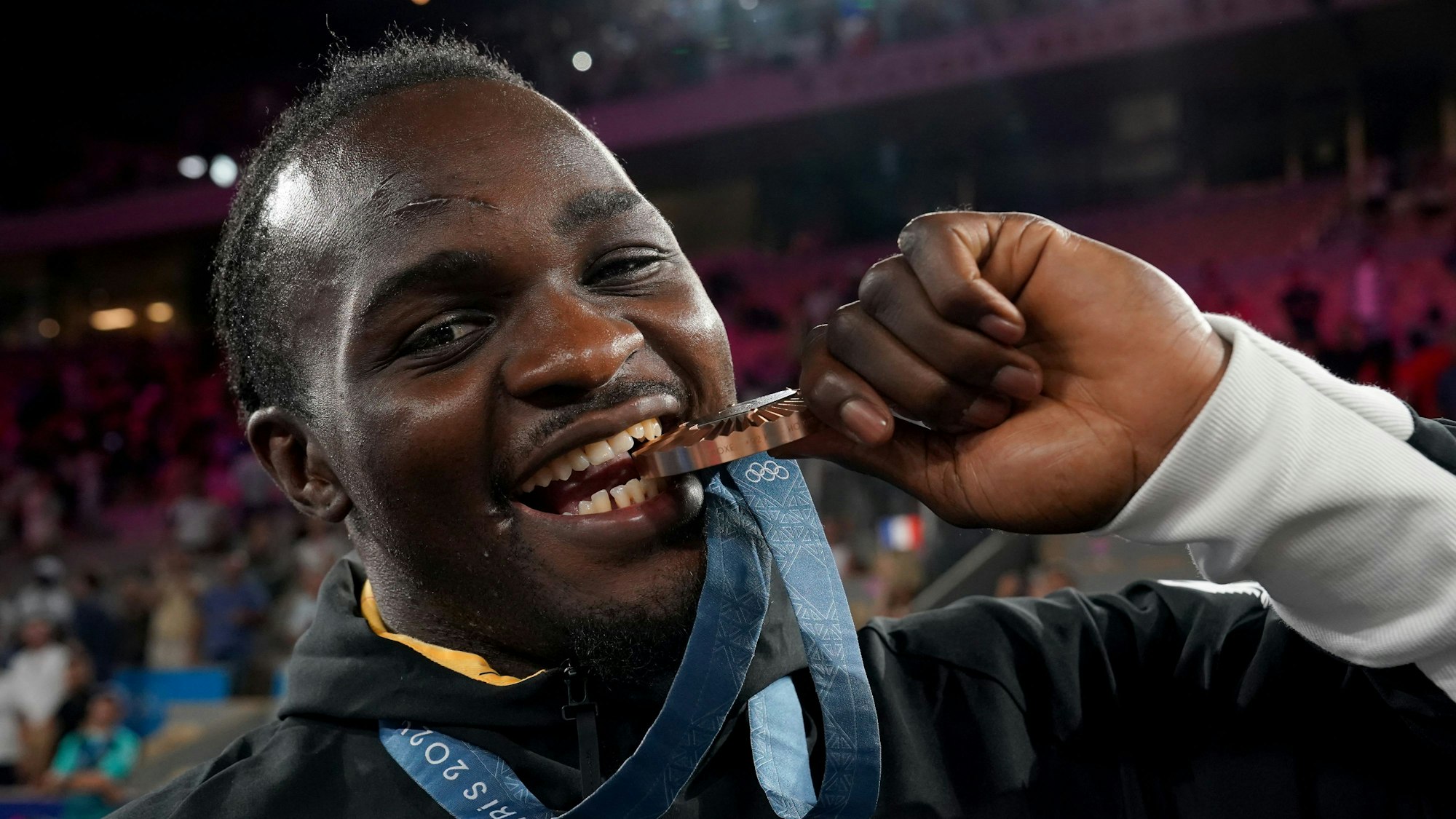 Deutschlands Nelvie Tiafack beißt in seine Bronzemedaille.