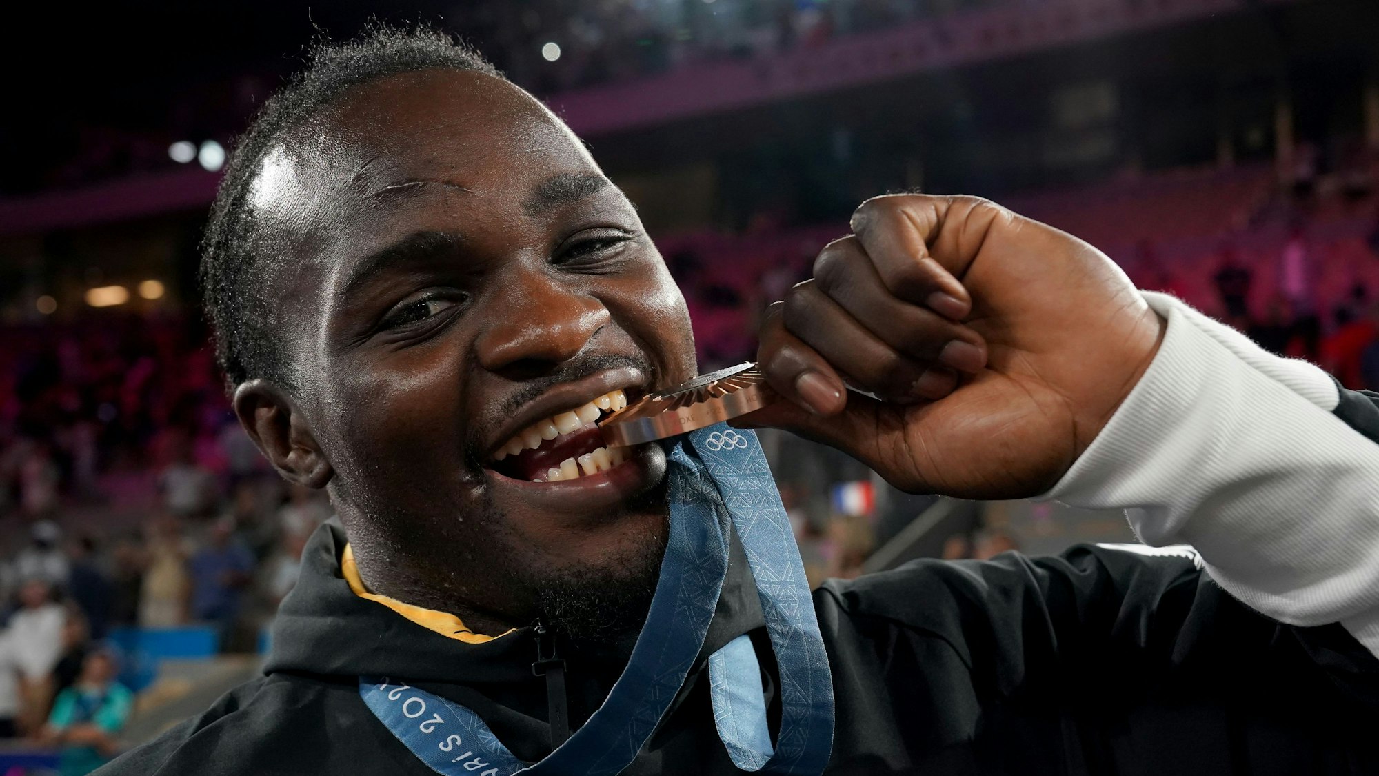 Deutschlands Nelvie Tiafack beißt in seine Bronzemedaille.