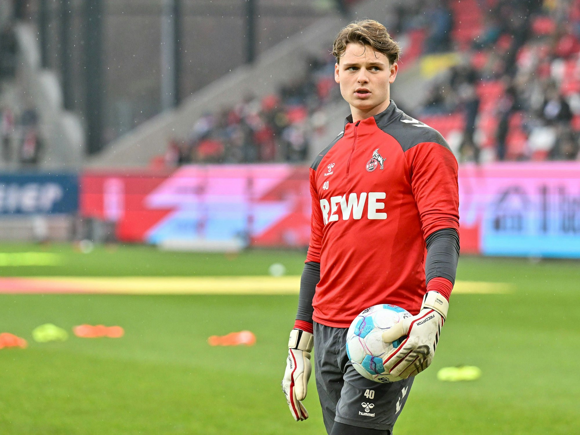 Jonas Urbig (1. FC Köln) mit Ball auf dem Platz.