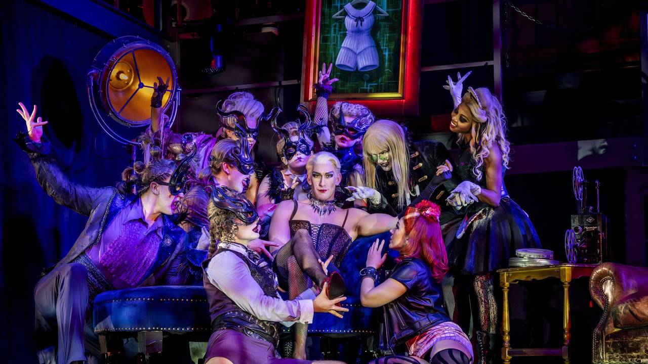 Frank’n’Furter (Mitte, Oliver Savile) wird von seinem Gefolge umringt.