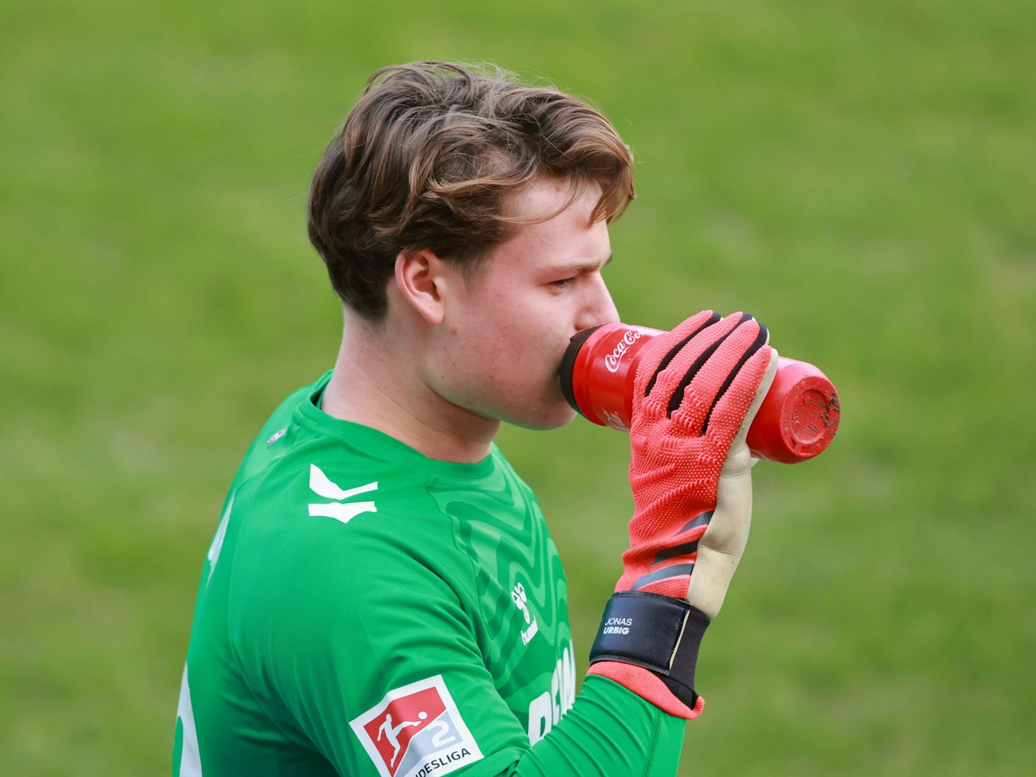 Jonas Urbig trinkt aus einer Flasche.