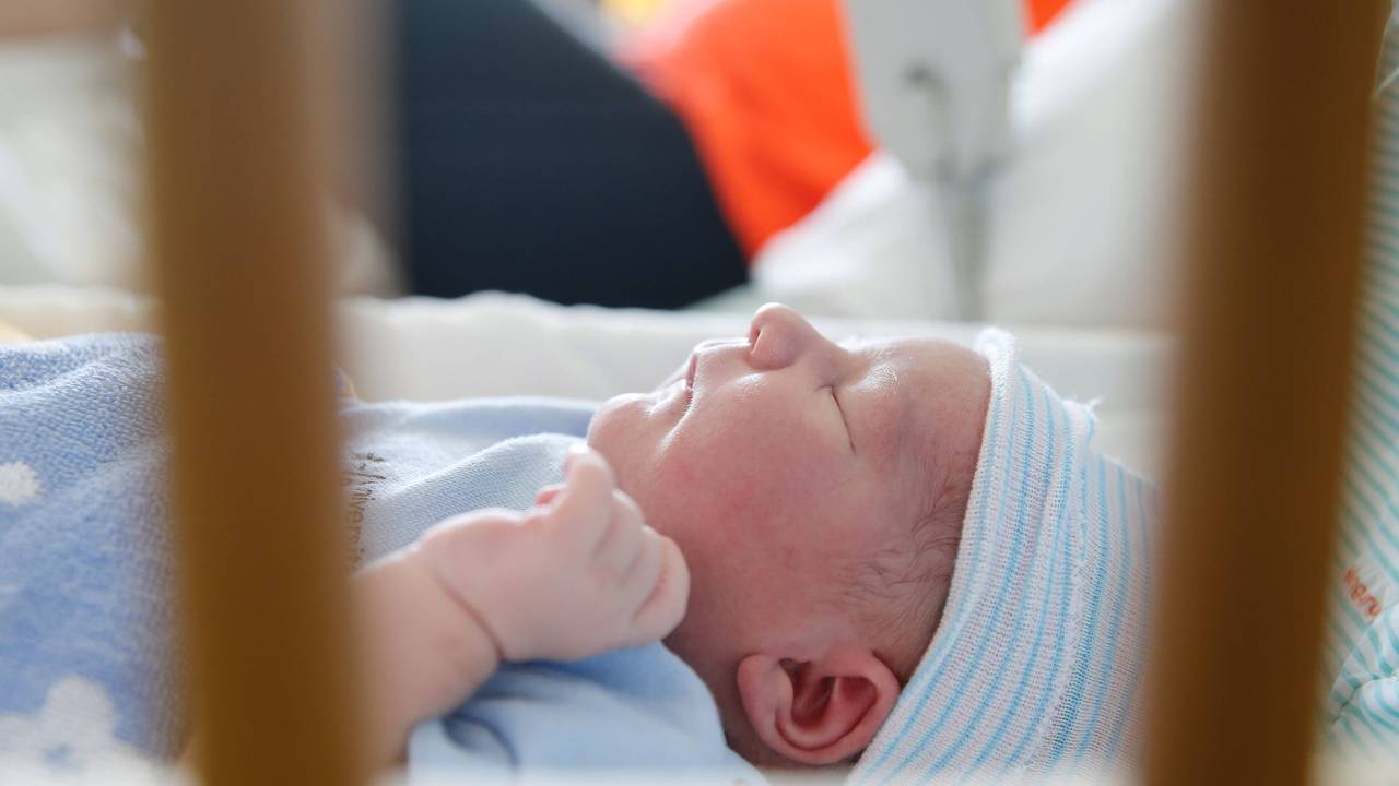Baby liegt im Bett auf einer Geburtenstation.