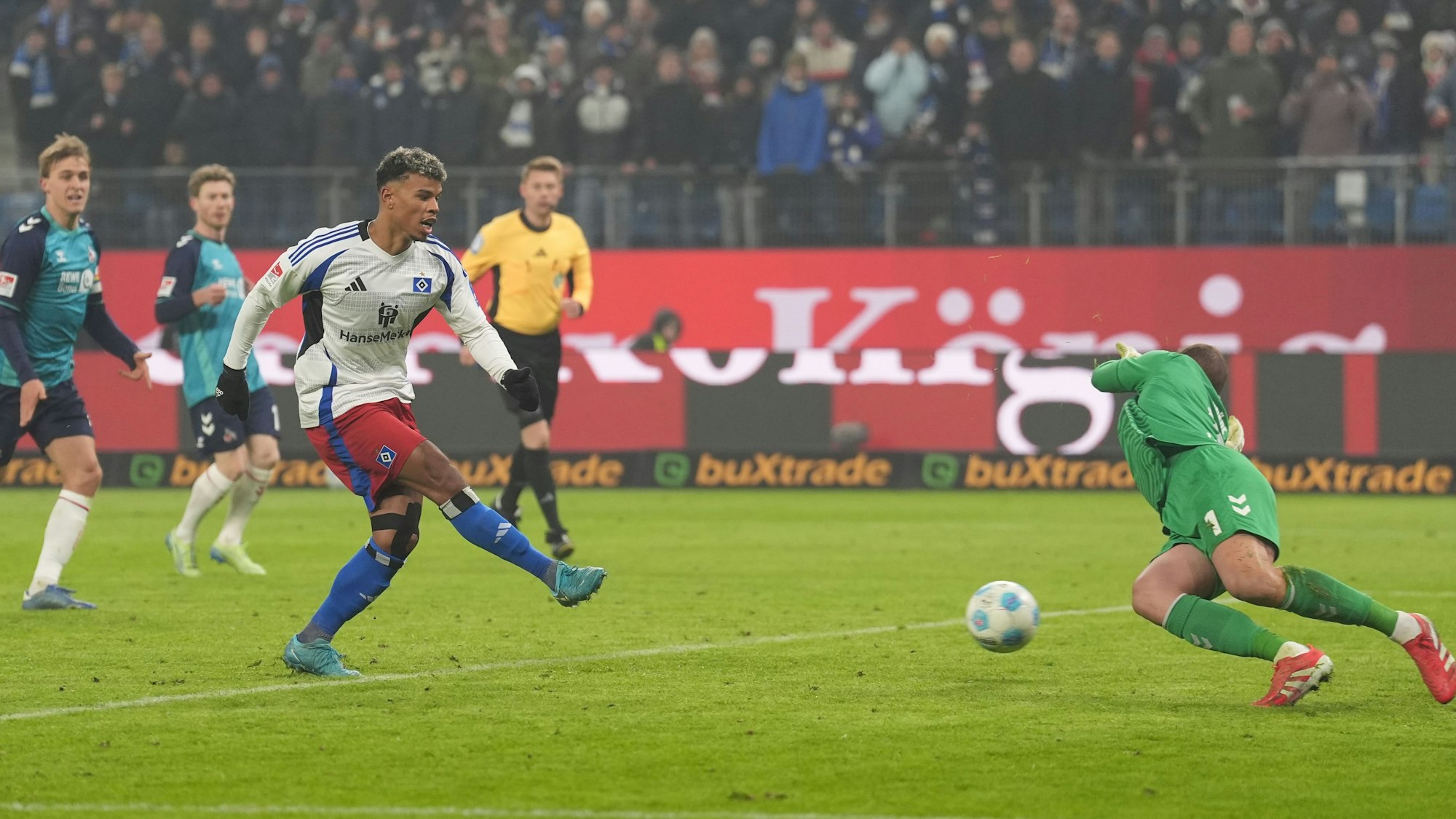 Hamburgs Ransford Königsdörffer (Mitte) erzielt gegen Kölns Torwart Marvin Schwäbe (r) den Treffer zum 1:0.