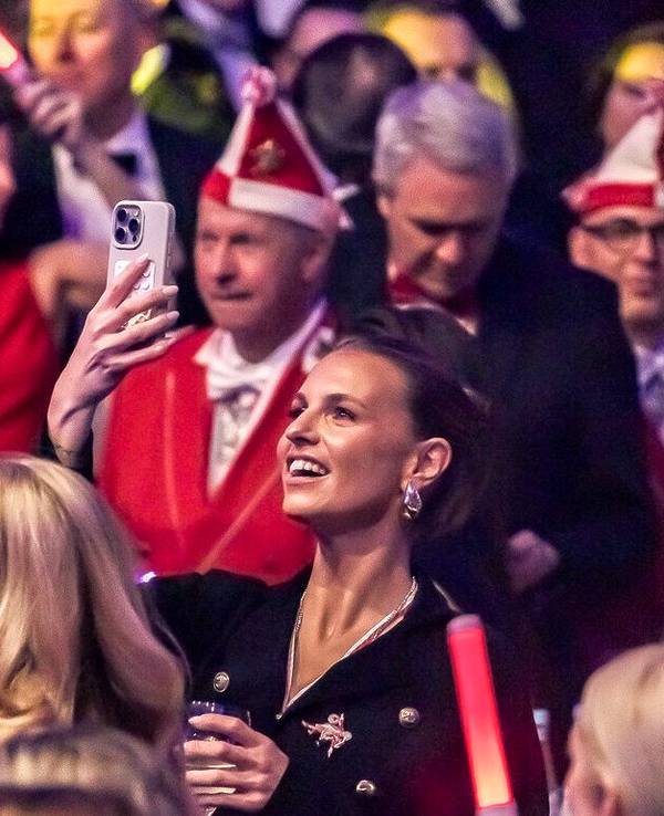 Laura Wontorra filmt mit dem Handy bei einer Karnevalssitzung.