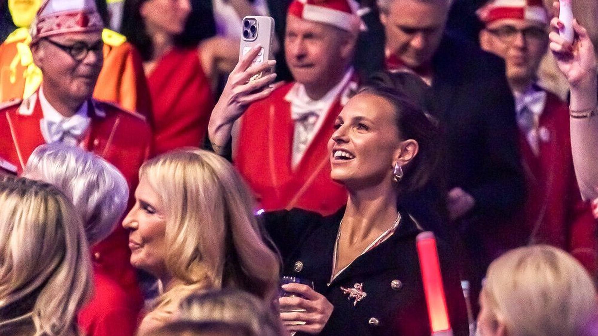Laura Wontorra filmt mit dem Handy bei einer Karnevalssitzung.