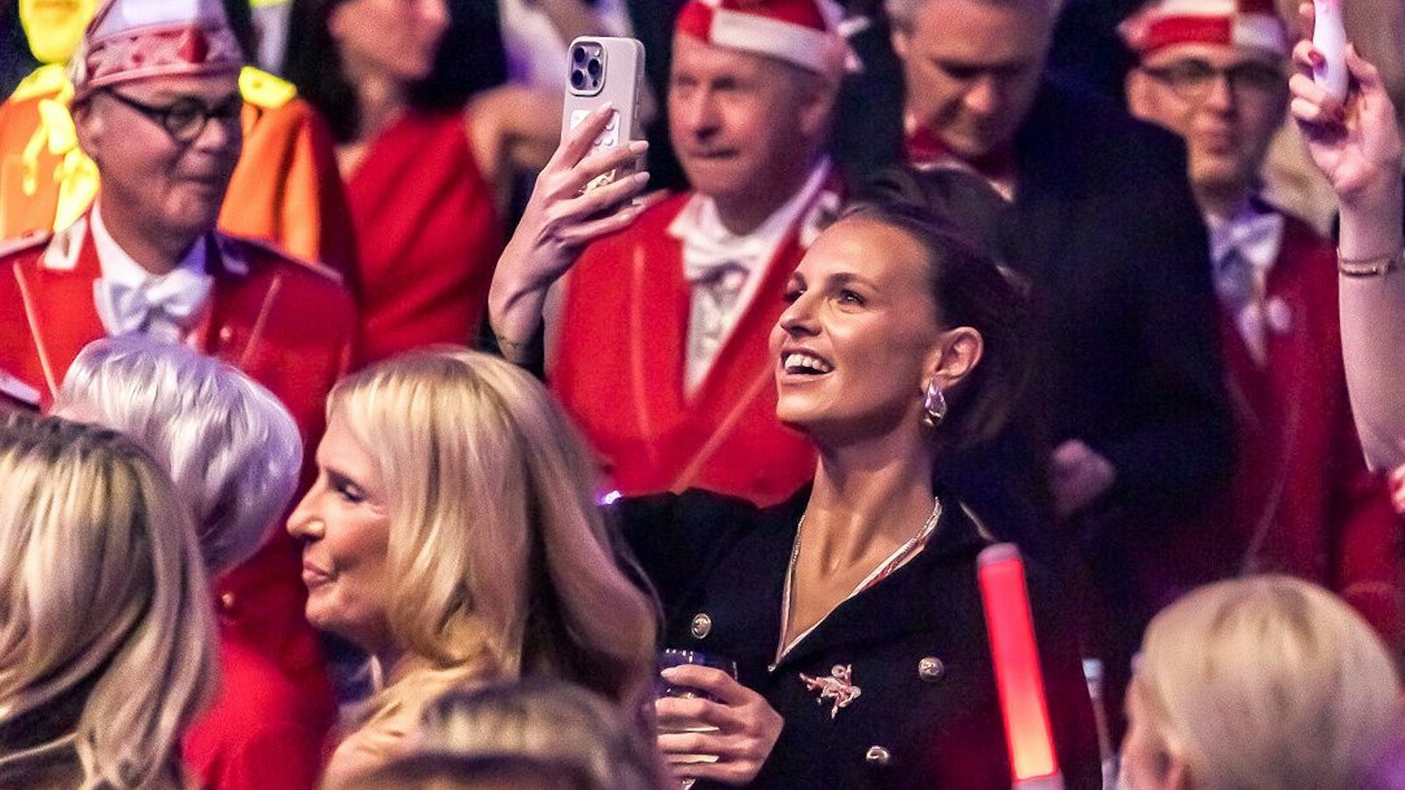 Laura Wontorra filmt mit dem Handy bei einer Karnevalssitzung.