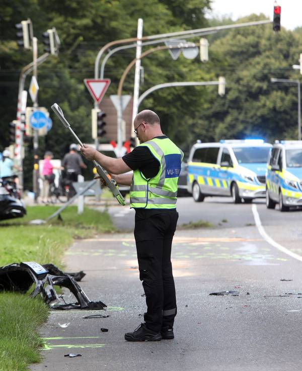 Einsatzkräfte der Polizei stehen an einer Unfallstelle und bewerten die Lage.