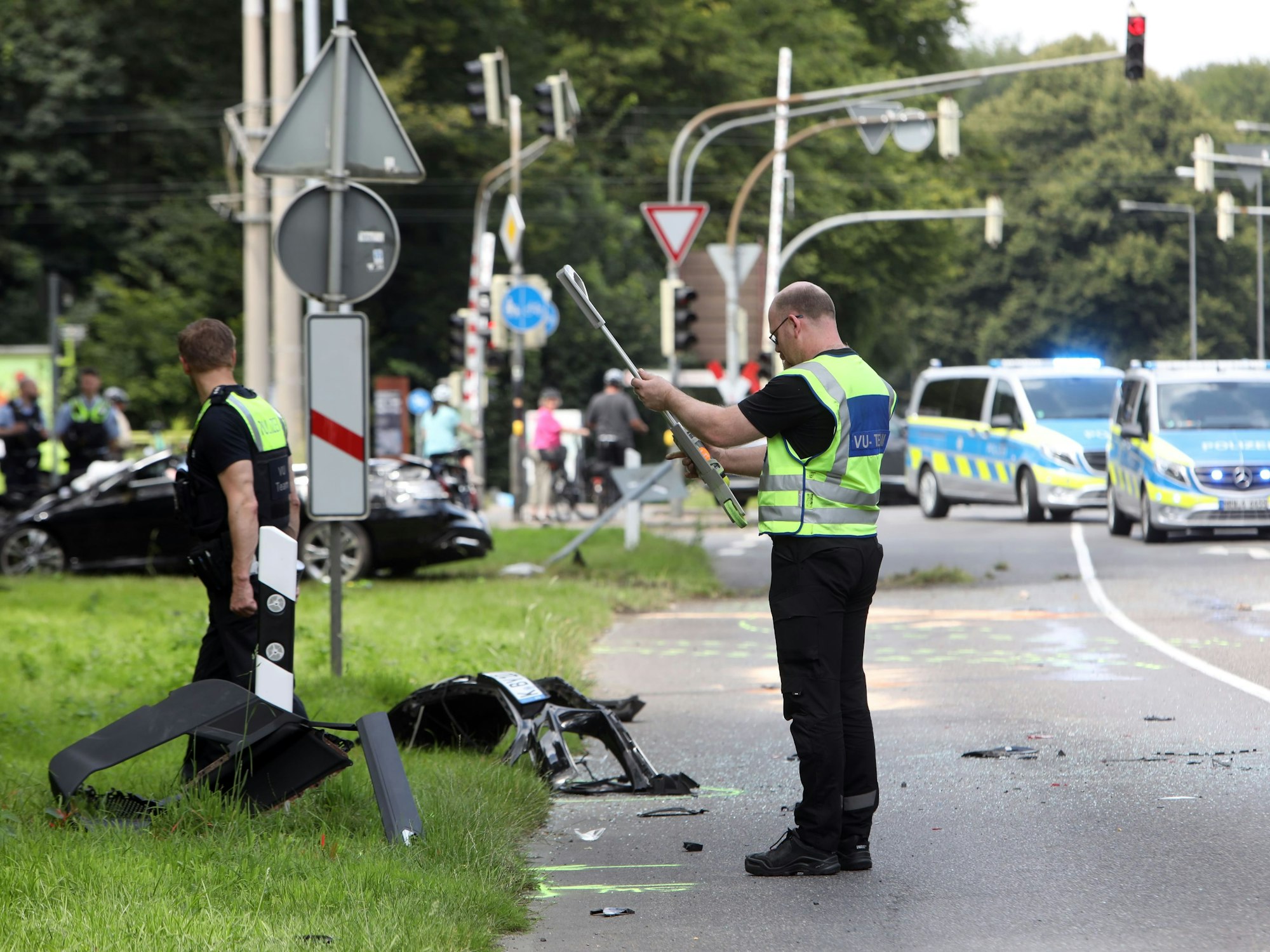 Einsatzkräfte der Polizei stehen an einer Unfallstelle und bewerten die Lage.