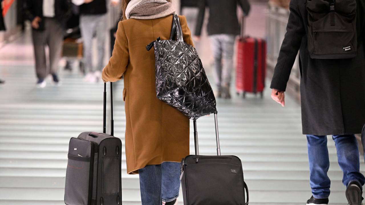 Passagiere gehen zum Check-In im Flughafen Köln/Bonn. Am ersten Tag der Weihnachtsferien erwarten Experten ein erhöhtes Verkehrsaufkommen.