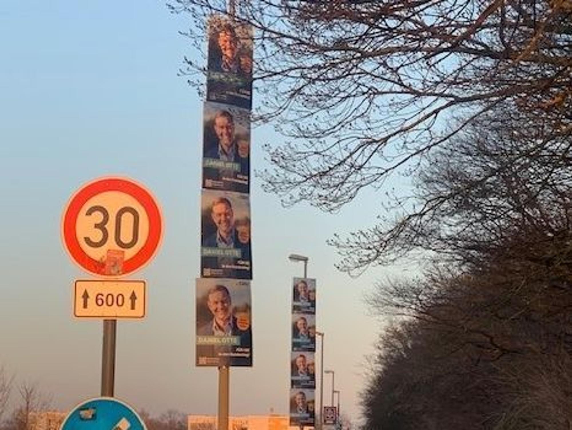 Wahlplakate hängen an Laternenmasten in Köln.