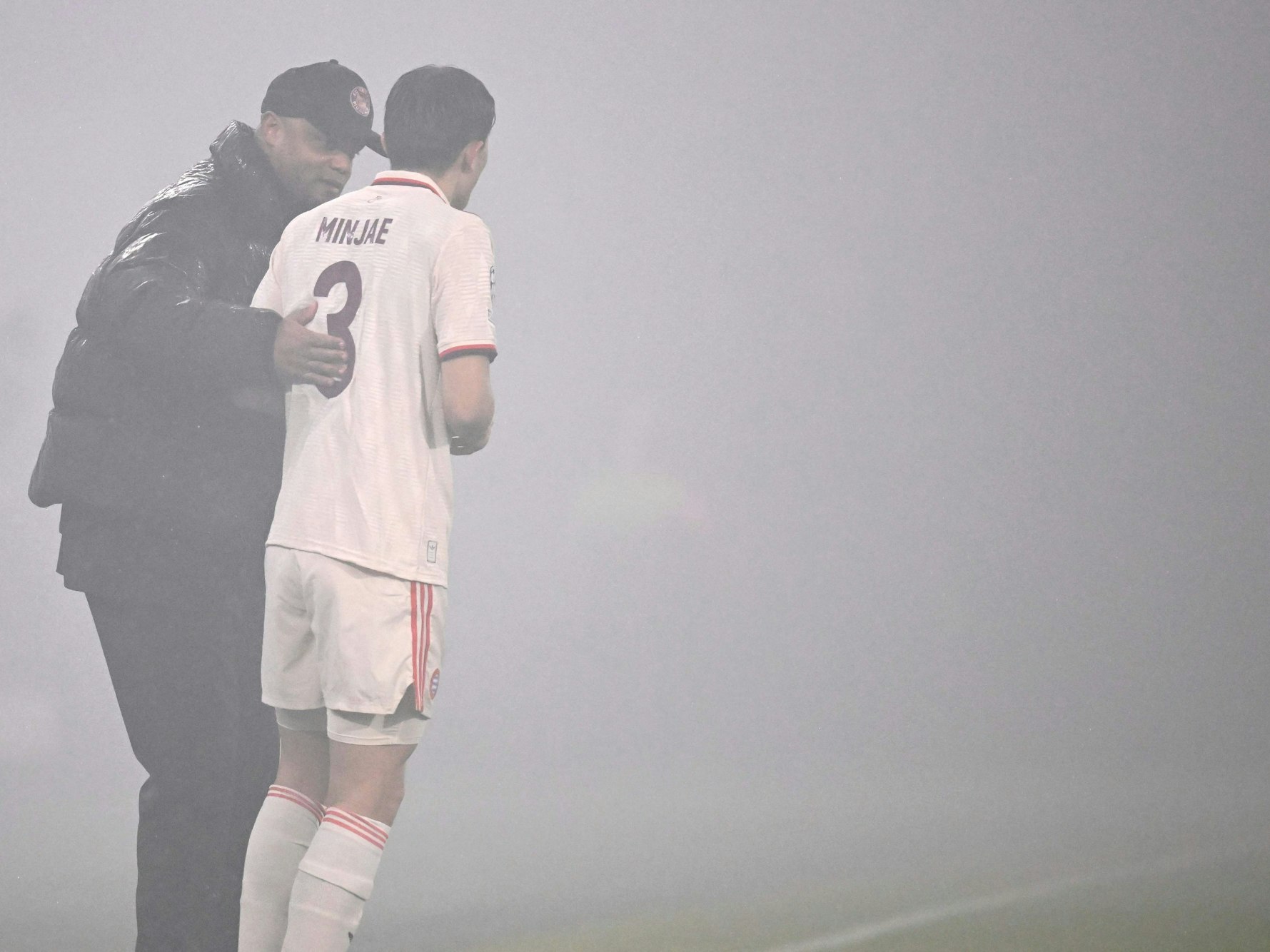 Vincent Kompany spricht im Rauchnebel mit Minjae Kim.