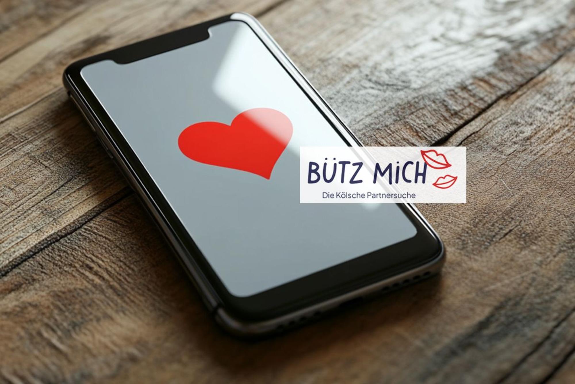 Ein Handy liegt auf einem Holztisch. Auf dem Display des Handys ist ein Herz zu sehen.