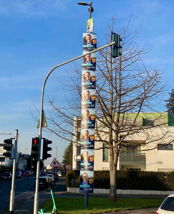 Wahlplakate hängen an einem Lichtmast