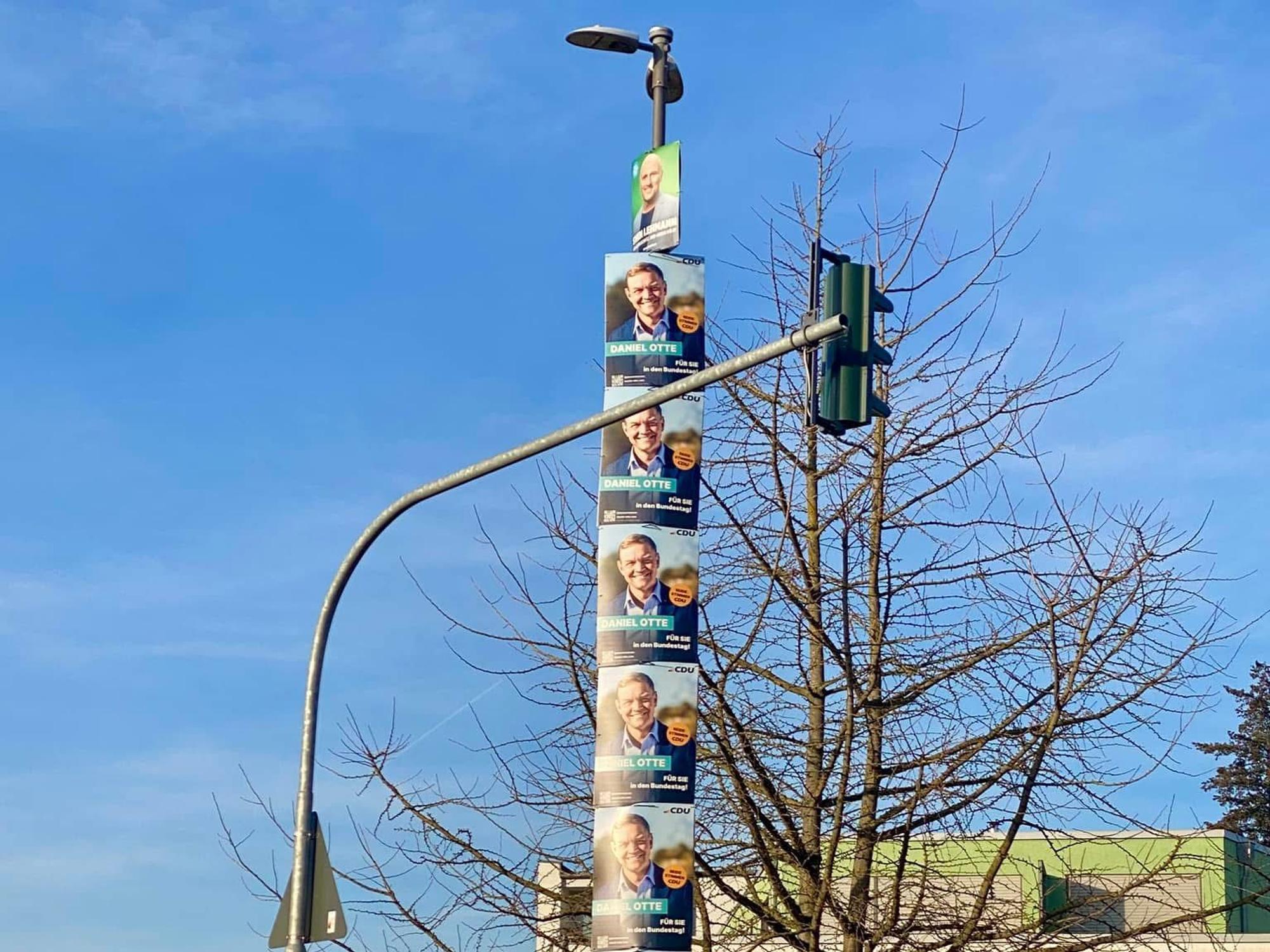 Wahlplakate hängen an einem Lichtmast.