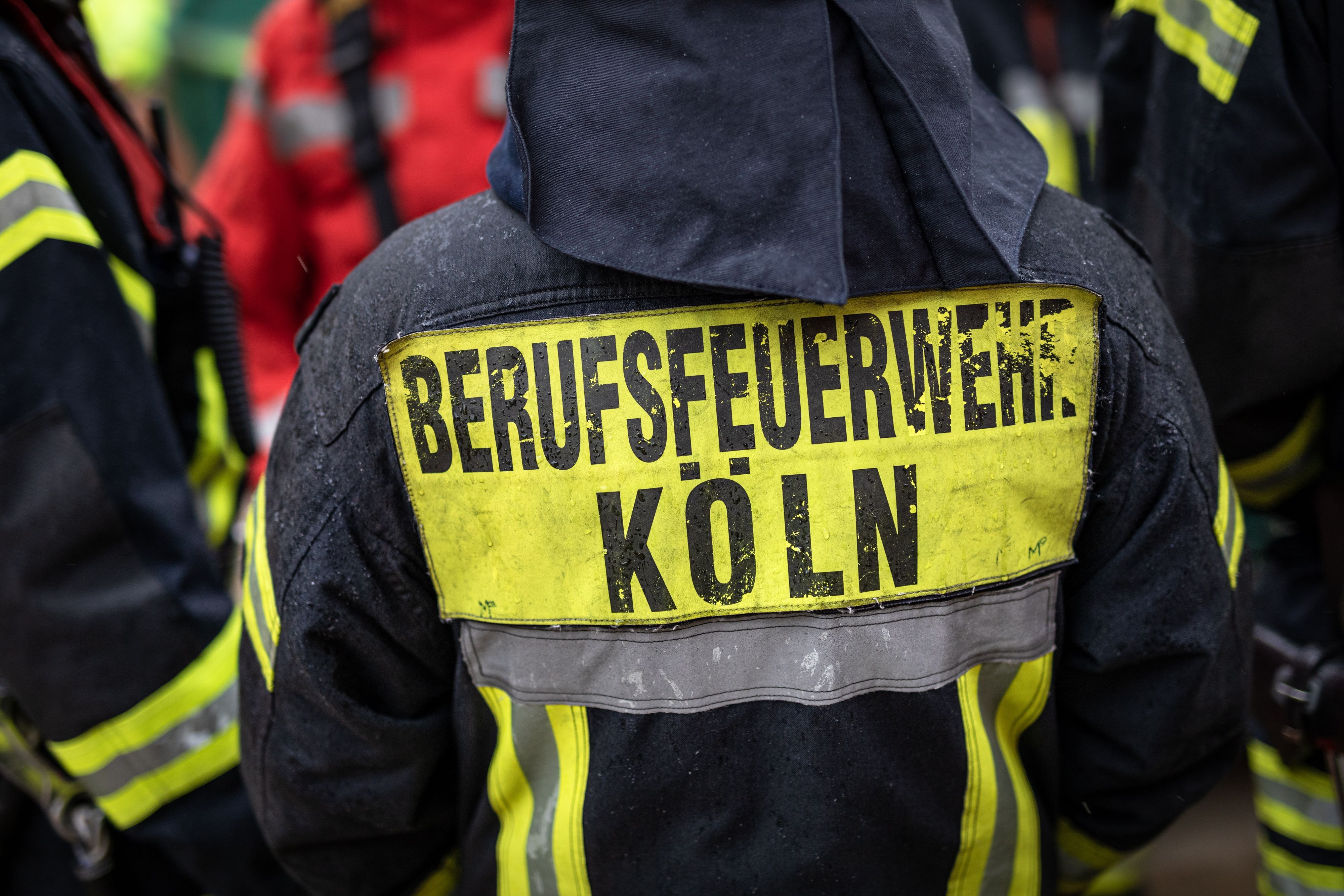 "Berufsfeuerwehr Köln" steht auf der Jacke eines Feuerwehrmann.