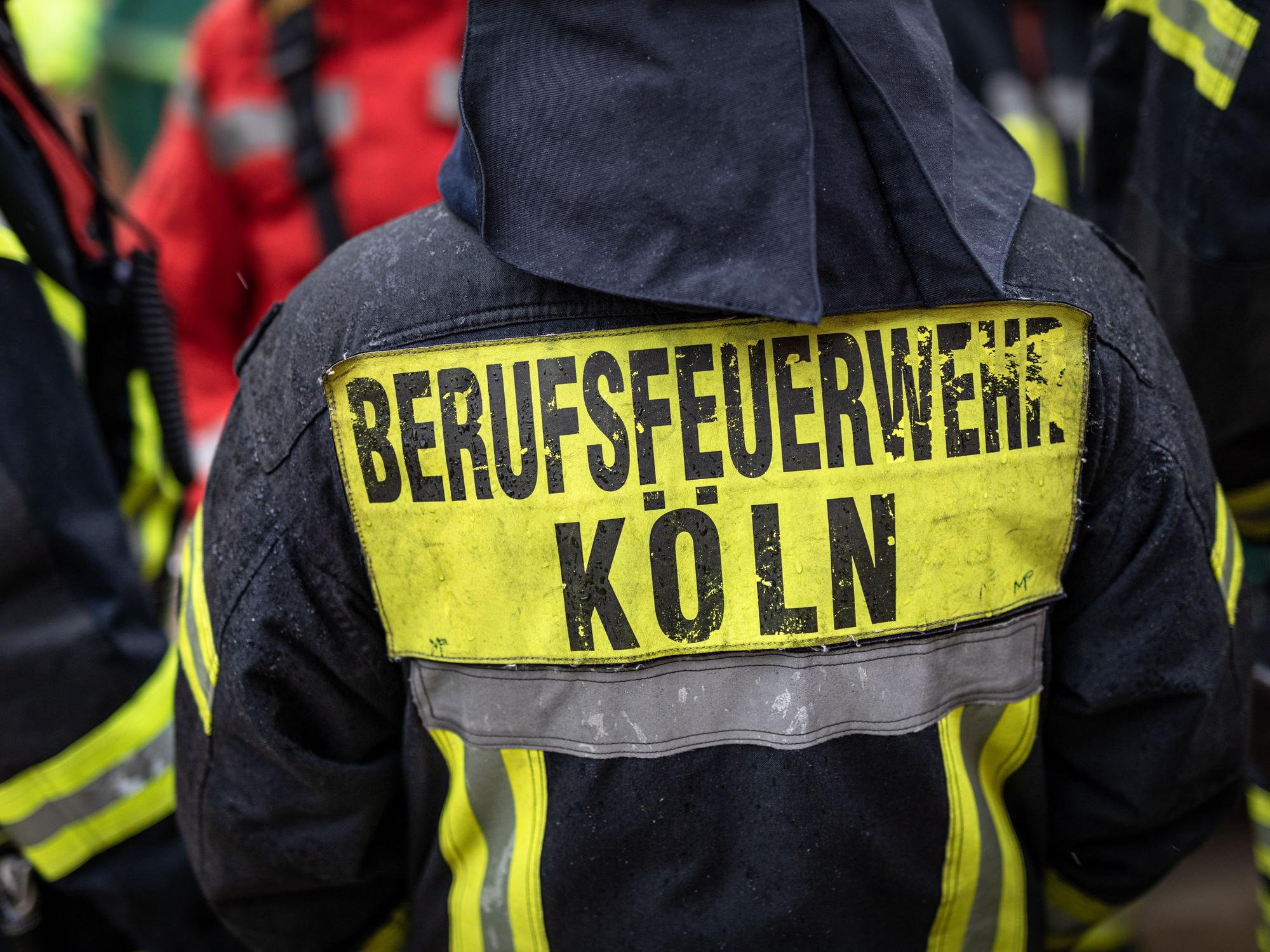 "Berufsfeuerwehr Köln" steht auf der Jacke eines Feuerwehrmann.