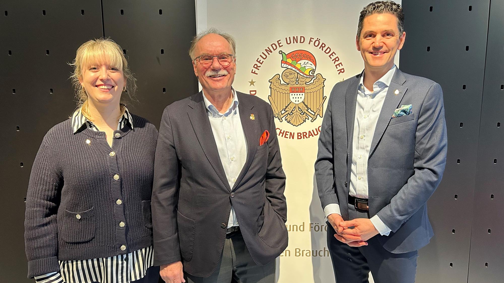 Johanna Cremer, Bernhard Conin und Dominik Bayartz stehen vor einem Banner.