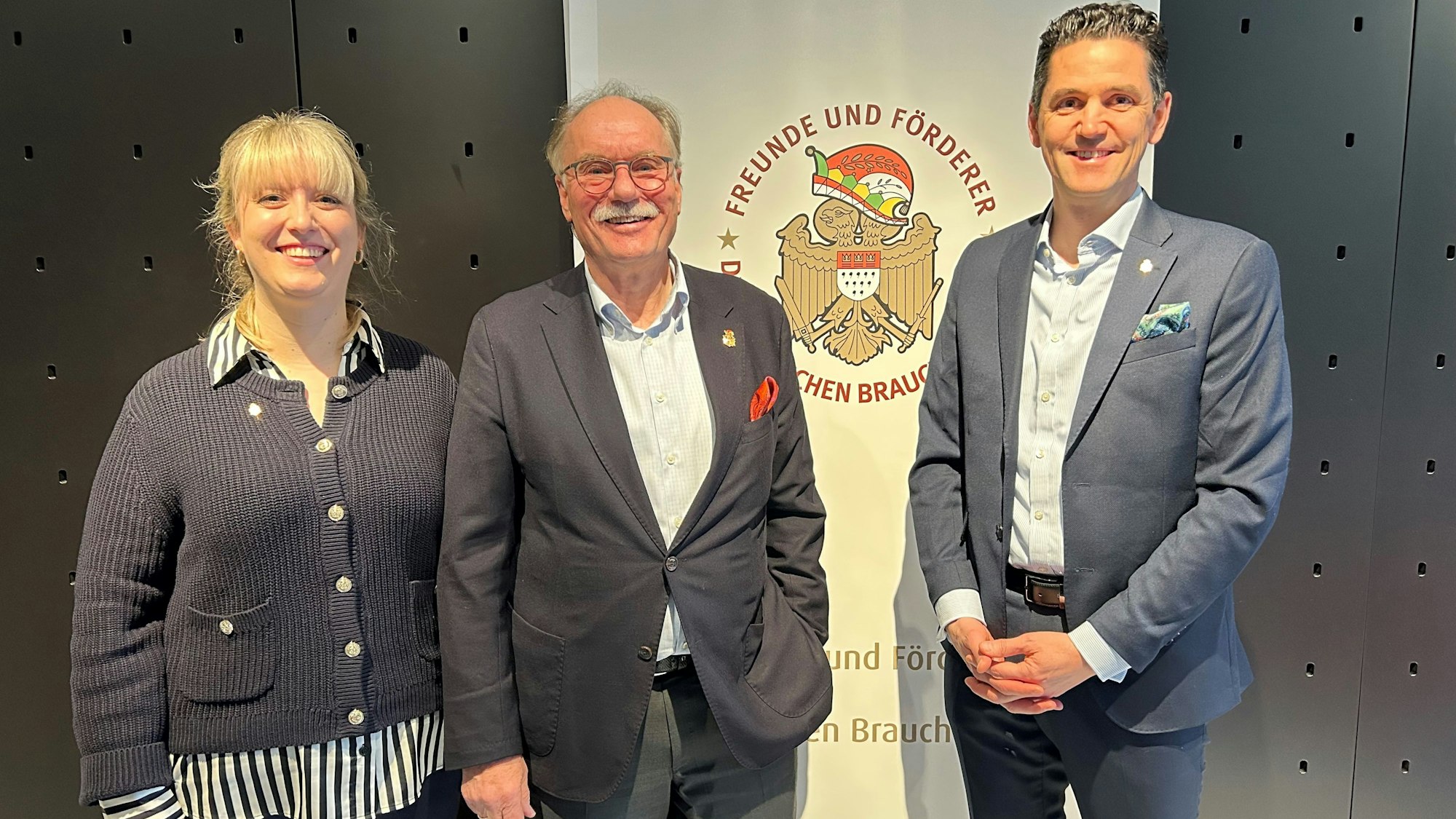 Johanna Cremer, Bernhard Conin und Dominik Bayartz stehen vor einem Banner.